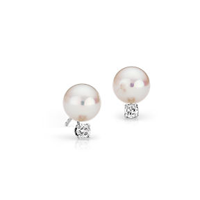 Des perles de culture d’Akoya sont entourées de diamants ronds avec des broches en or blanc 18 carats.