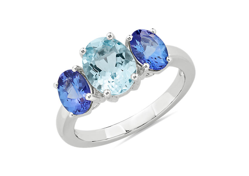Two oval-cut tanzanite stones accent either side of a oval-cut aquamarine gemstone engagement ring center set in white gold