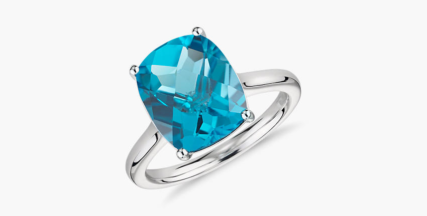 Un anillo de compromiso con topacio azul de talla cojín engarzado en oro blanco.