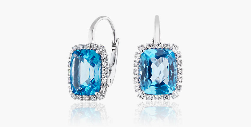 A pair of cushion-cut December birthstone earrings of Swiss Blue Topaz detailed with diamond halos set in white gold lever back drops