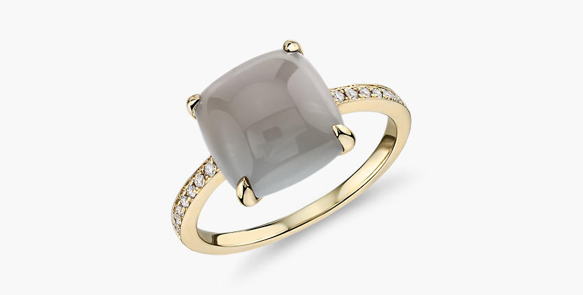 Un anillo de compromiso con piedra lunar gris engarzado en oro amarillo.