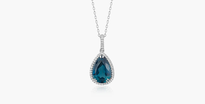 A pear shaped london blue topaz gemstone featured in a silver pendant