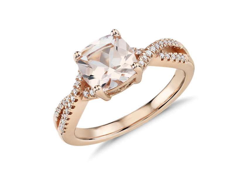 Un anillo de compromiso con morganita de talla cojín adornada con pavé de diamantes en un diseño torcido del infinito y engarce de oro rosado.