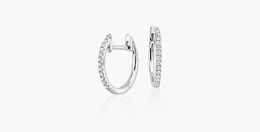 A pair of April birthstone huggie earrings accented with round diamond pavé