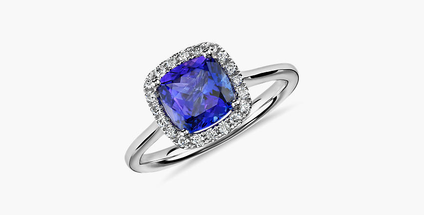 Un anillo de compromiso de tanzanita cuadrada con halo de diamantes en pavé y engarce de oro blanco