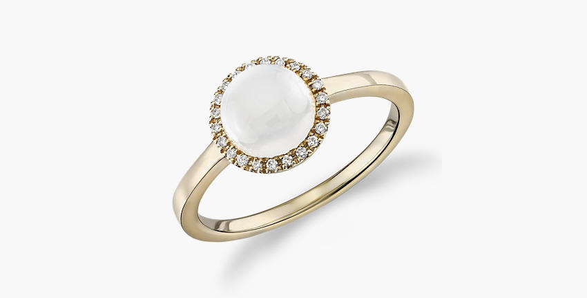 White moonstone featured in a cahochon ring with diamond halo