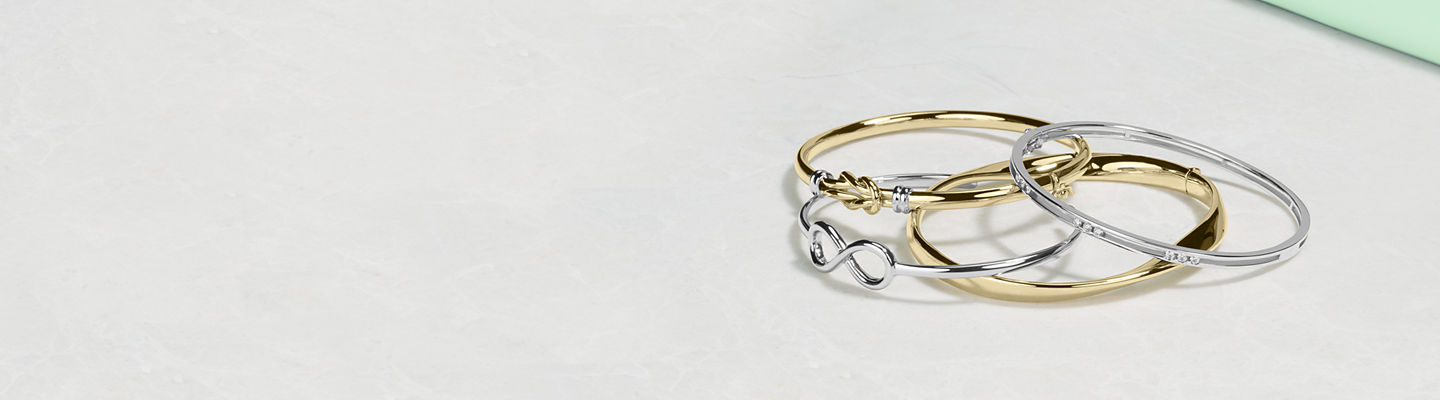 Superposition de quatre bracelets jonc en or jaune et or blanc.
