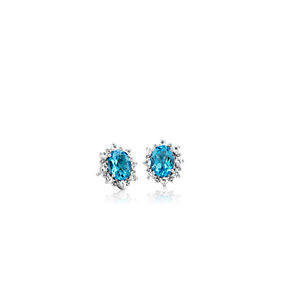 Oval stud earrings set with Swiss blue topaz surrounded by a sunburst of white topaz.