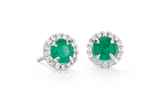 Emerald earrings surrounded by a halo of brilliant round diamonds in 18k white gold.