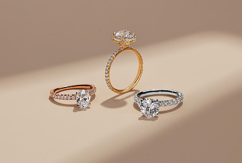 Three engagement rings with center stones and pave