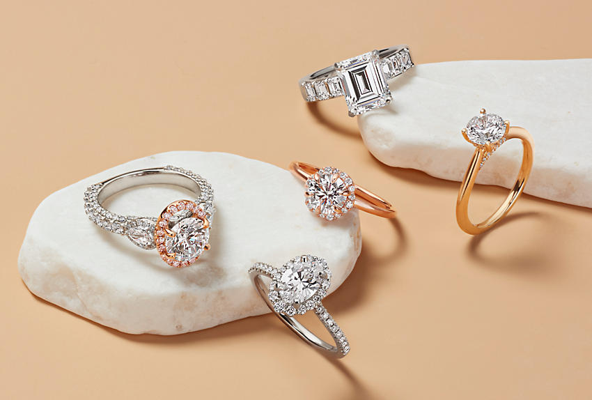 An assortment of engagement rings featuring solitaires, halos, pavé and a three stone ring
