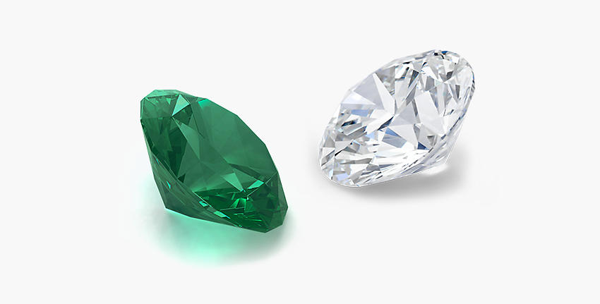A loose emerald gemstone faces to the left across from a loose diamond gemstone facing to the right