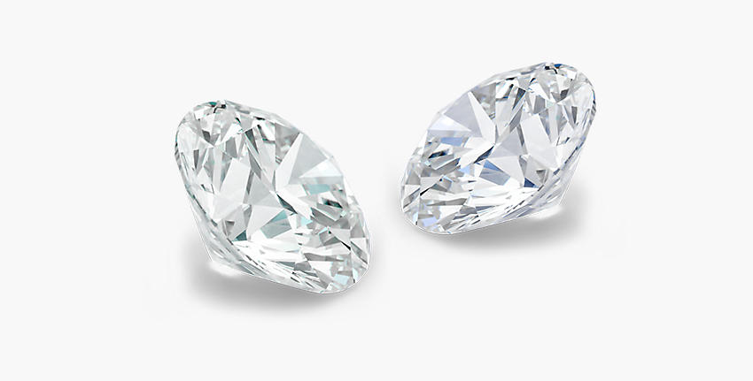 Una gema de moissanita suelta orientada hacia la izquierda frente a un diamante suelto orientado hacia la derecha